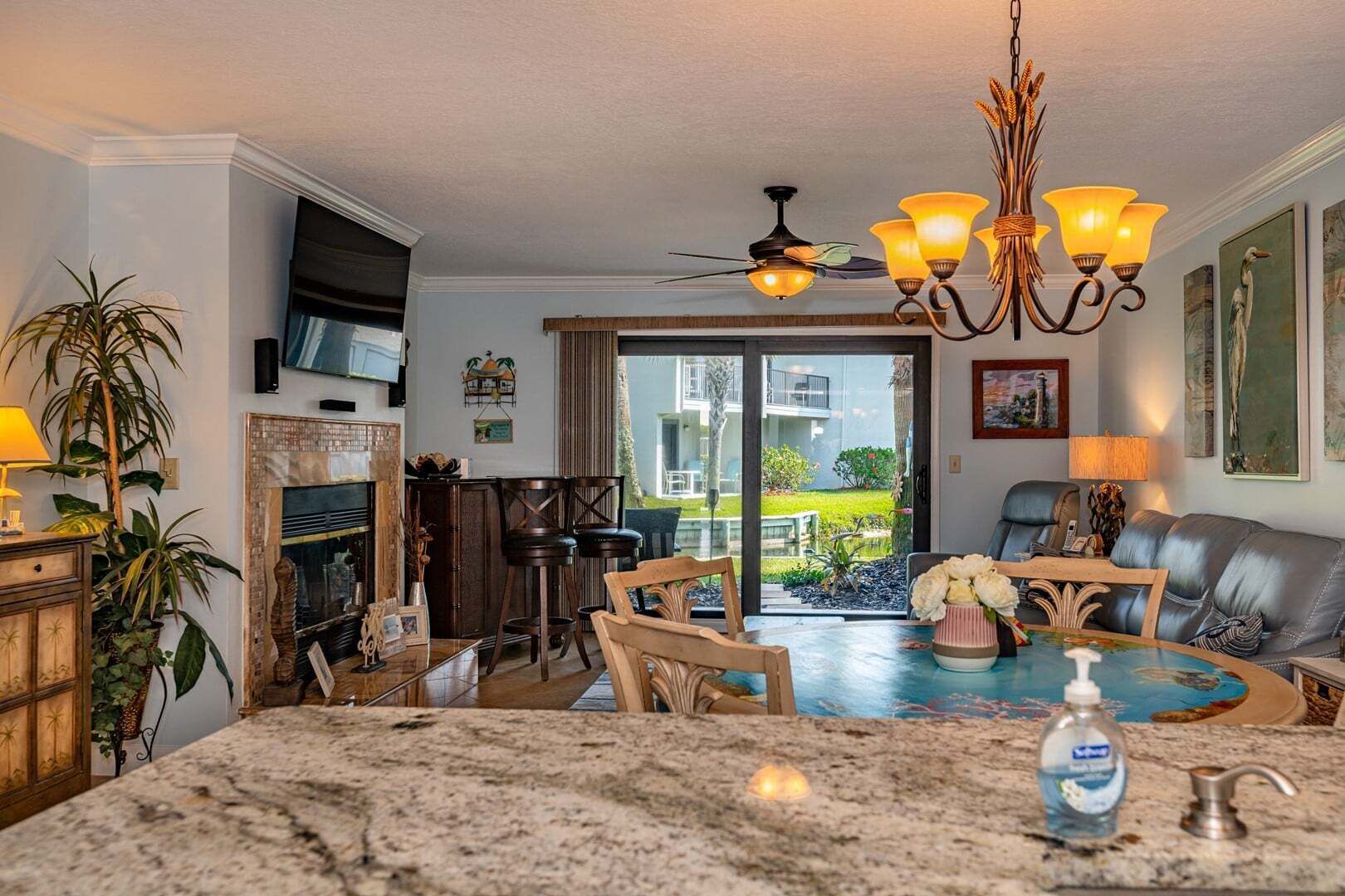A spacious living area with a large dining table, a fireplace, and a view of the outdoors.