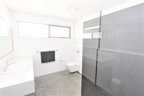 A bathroom with a white sink, a toilet, a towel rack, and a window. - The ultimate property for the family with amazing views to whale watch (Crowdy Head)