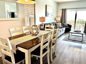 Enjoy meals with family and friends in this cozy living area, featuring a dining table for four and a comfortable sofa.