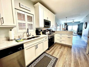 Enjoy meals in this kitchen with a central island, microwave, and dishwasher, leading to a dining area with city views.