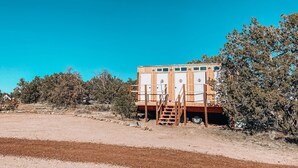 Una casa móvil con terraza de madera y una escalera que lleva a la entrada.