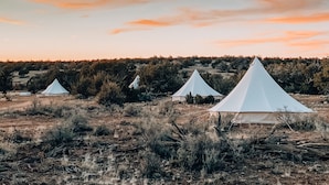 Una serie de tiendas blancas en un paisaje natural con cielo despejado.