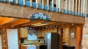 A cozy cabin interior with a living room, kitchen, and dining area.
