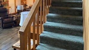 A wooden staircase with a handrail leading to an upper level.
