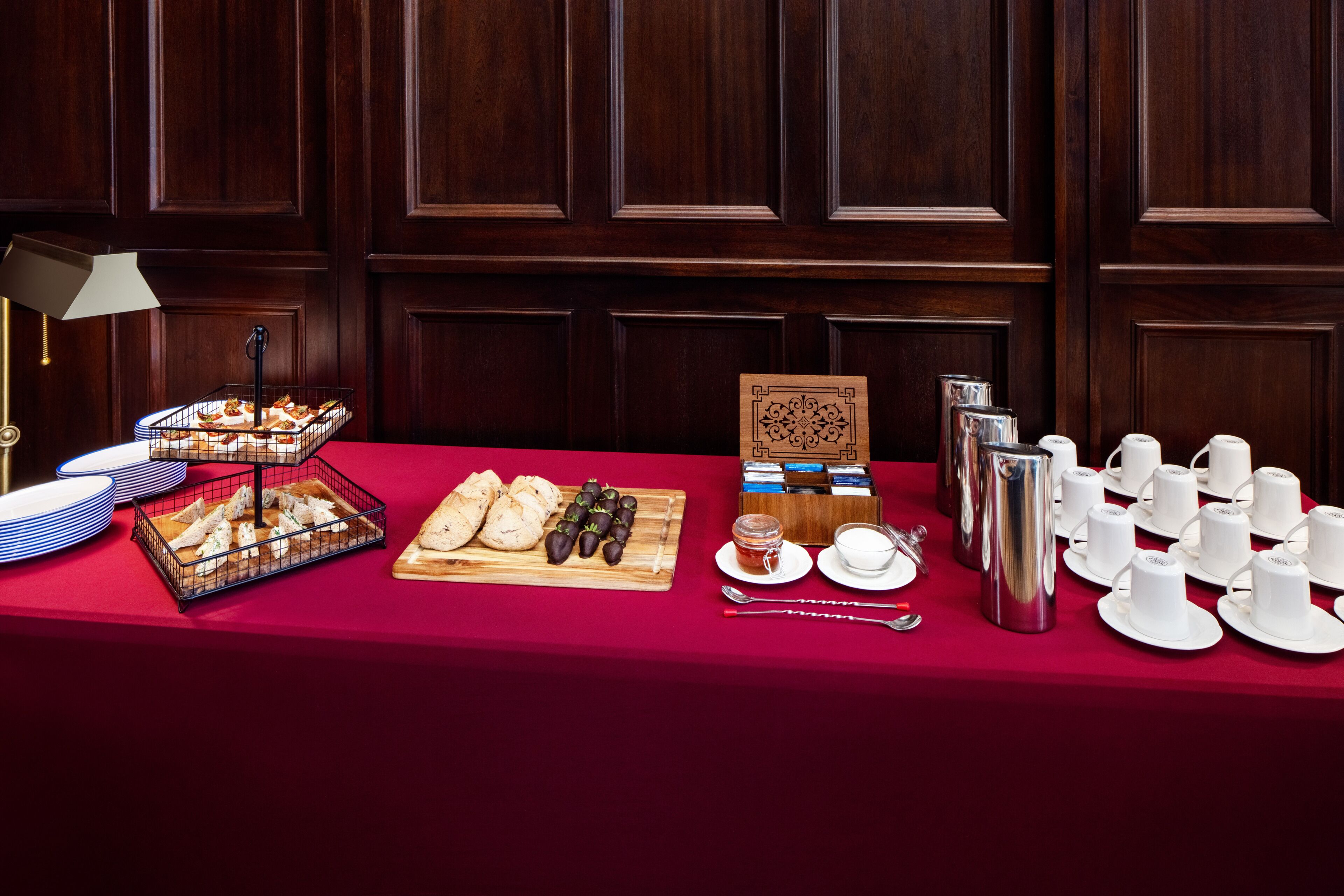 Une table de buffet proposant une variété d’aliments, notamment des pâtisseries, des fruits et un coin café.