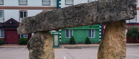 Un banco de piedra en un área verde, con un edificio al fondo.