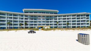 A multi-story hotel with balconies, a beach view, and a sandy foreground. - Beach Service|Gulf Front|Private Balcony|PCB|CC514 (Panama City Beach)