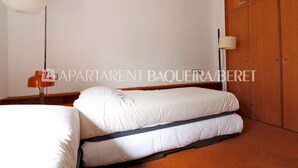 Een slaapkamer met een bed, een kledingkast en een lamp.