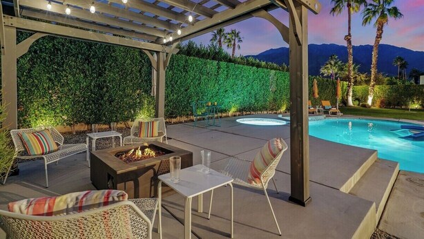 An outdoor patio with a fire pit, seating, and a pool. - Palm Springs Oasis - Palm Springs Perfection: Relax, Play & Recharge in Your Own Oasis (Palm Springs)
