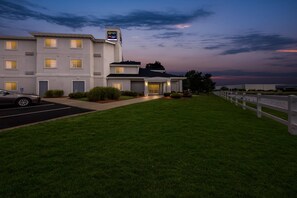 A multi-story hotel with a parking lot and a well-maintained lawn. - Quality Inn Fishers - Indianapolis (Fishers)