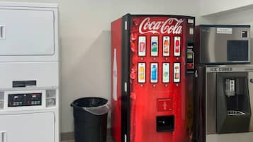A vending machine with Coca-Cola and Sprite options, a trash bin, and an ice cube dispenser.