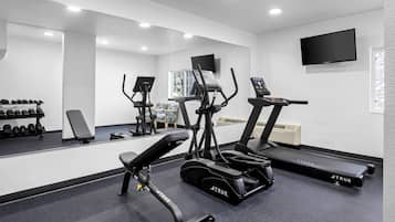 A gym with treadmills, ellipticals, and free weights.