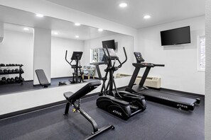 A gym with treadmills, ellipticals, and free weights. - Quality Inn Fishers - Indianapolis (Fishers)