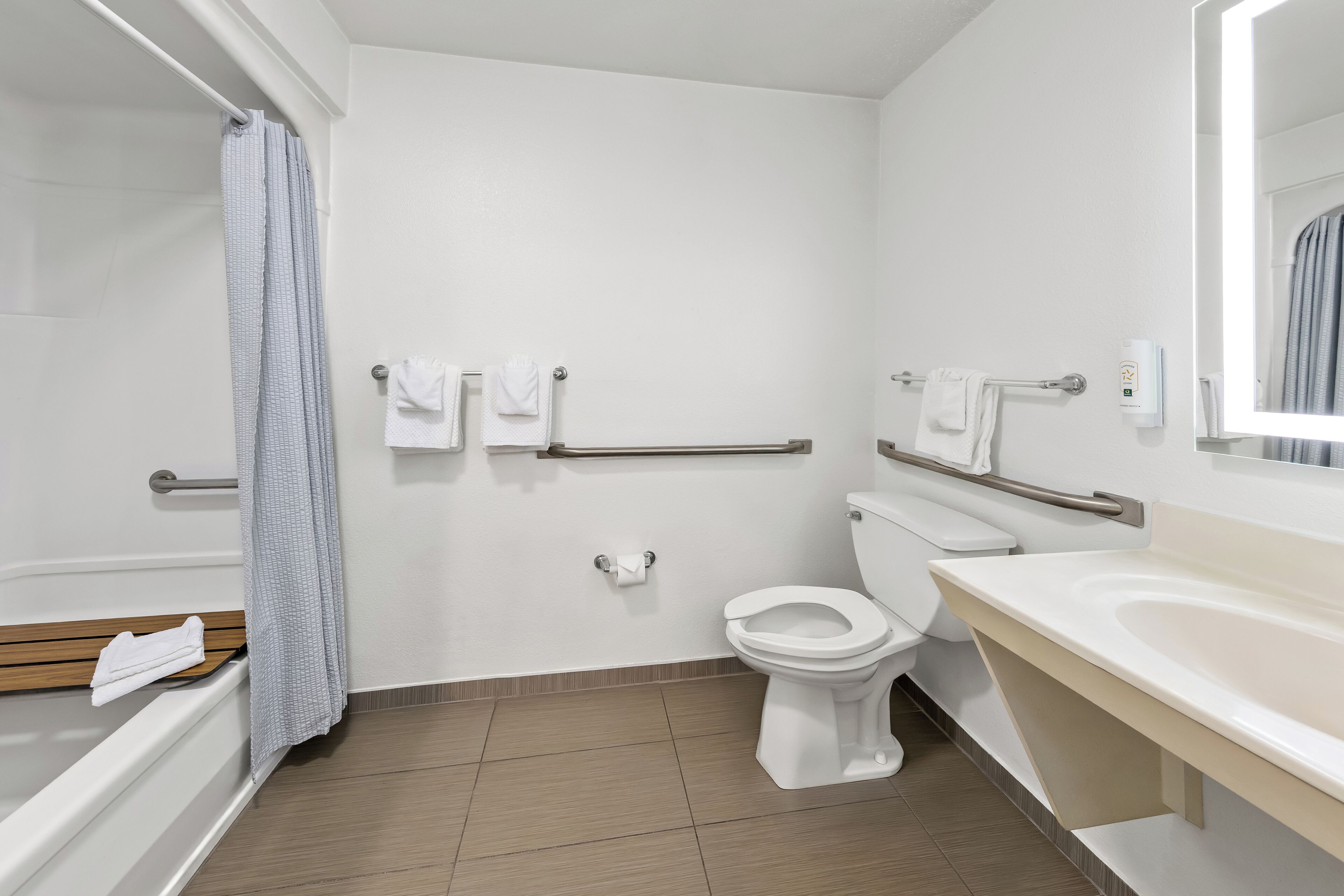 A bathroom with a toilet, a sink, a shower, and a towel rack.