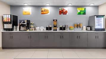A modern kitchenette with a coffee machine, waffle maker, and a refrigerator.
