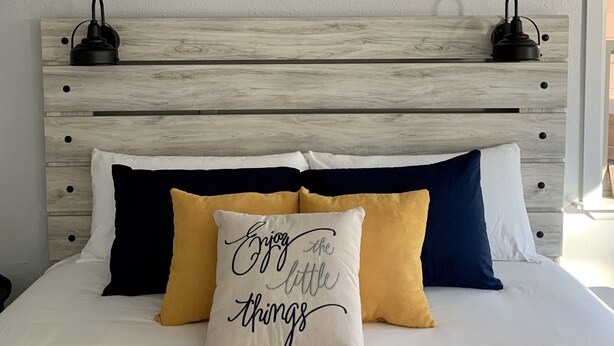 A bed with a wooden headboard, three framed pictures above it, and a pillow with a motivational quote. - Simply Relax in the Mountains! (Cloudcroft)