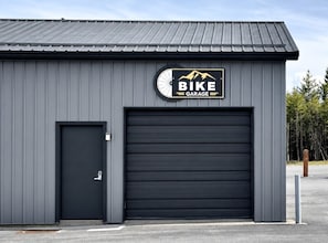 Ein Gebäude mit einem Schild 'BIKE GARAGE', einer geschlossenen Garagentür und einer kleinen Tür links.