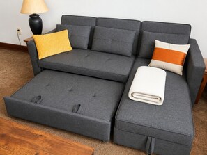 A grey sectional sofa with a matching ottoman, a yellow throw pillow, and a white throw pillow. - ML217 Slopeside Retreat Close to Village & Ballhooter EZ Park Wi-Fi Sleeps 4 (Snowshoe)