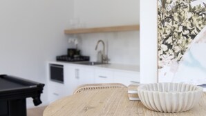 Una cocina con armarios blancos, una encimera de madera y un fregadero.