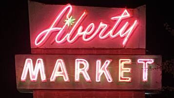 A neon sign for 'Alberta Market' at night.
