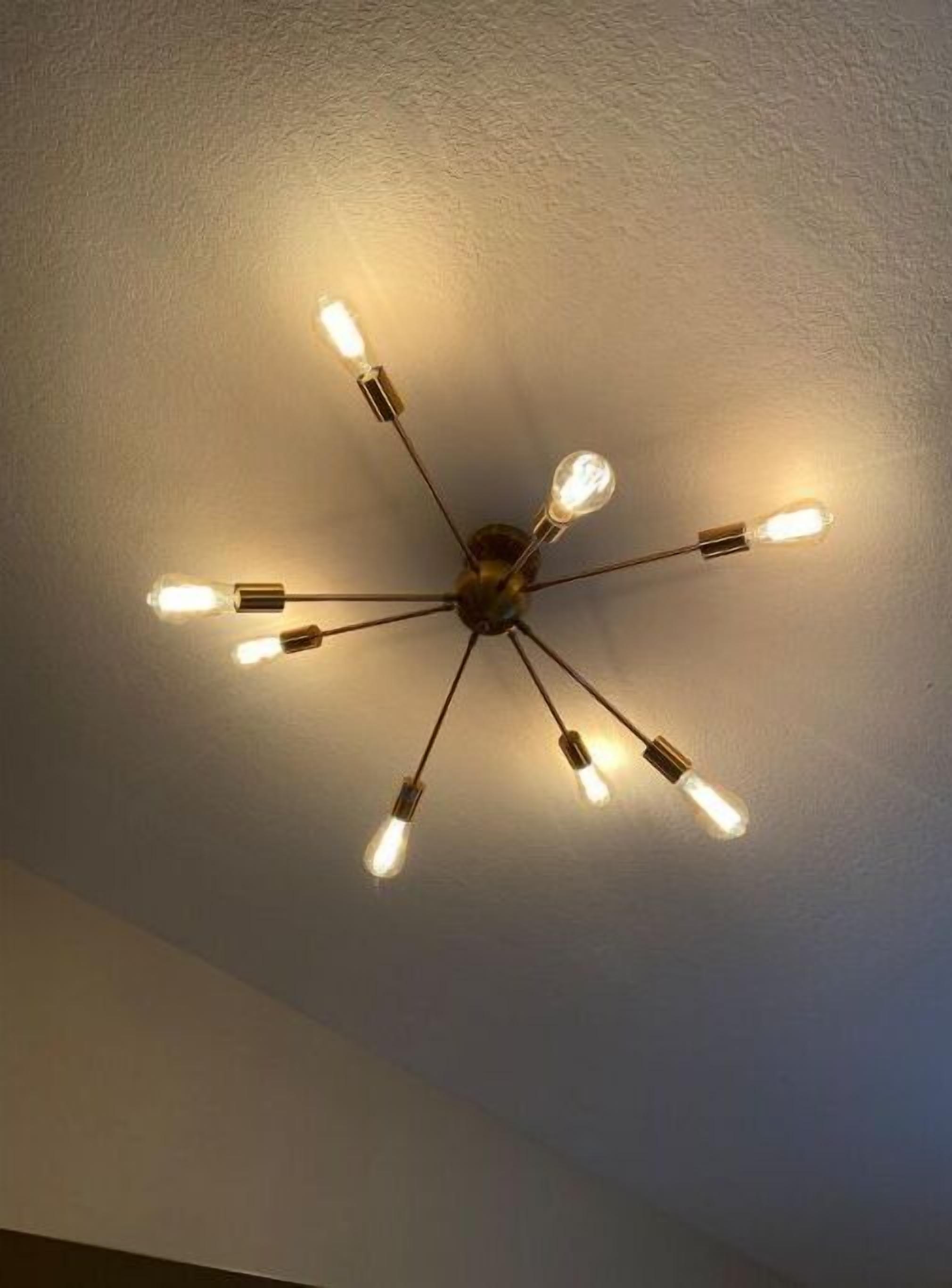Un ventilateur de plafond doté de plusieurs ampoules.
