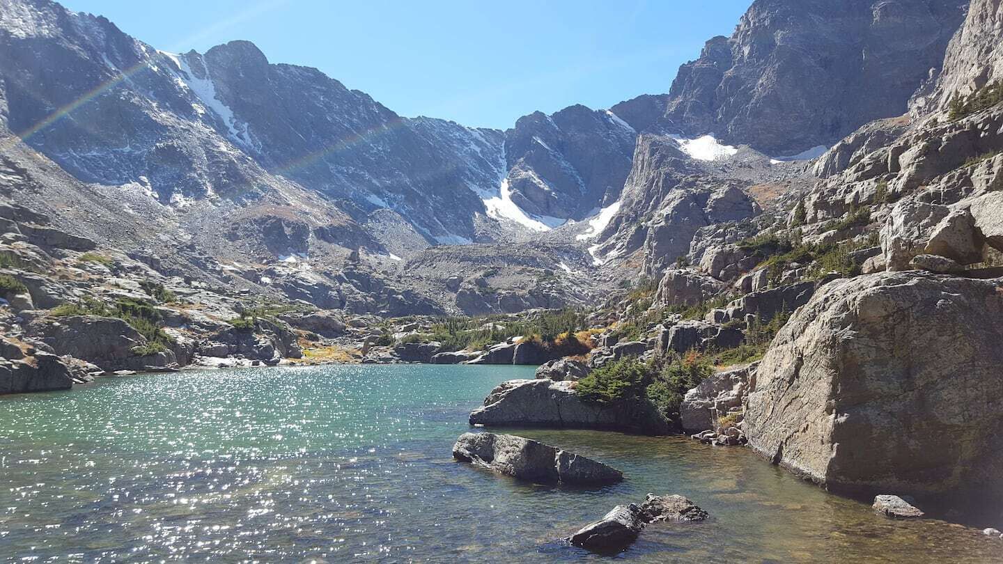A mountain lake surrounded by rocky terrain and snow-capped peaks.