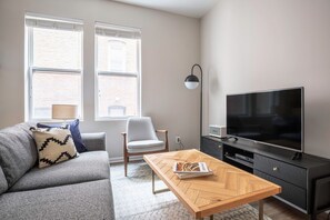 Relax in this stylish living room with a sofa, armchair, and coffee table, perfect for unwinding with a good book or watching TV.