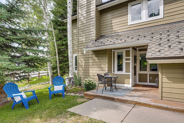A house with a deck, two blue Adirondack chairs, a small table, and a window. - Hike, Ski & Golf: Fully Renovated Edwards Townhome (Edwards)