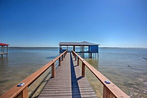 A wooden pier leading to a small dock with a covered structure. - Game Room + Lake Tawakoni Access: Family Getaway! (Quinlan)