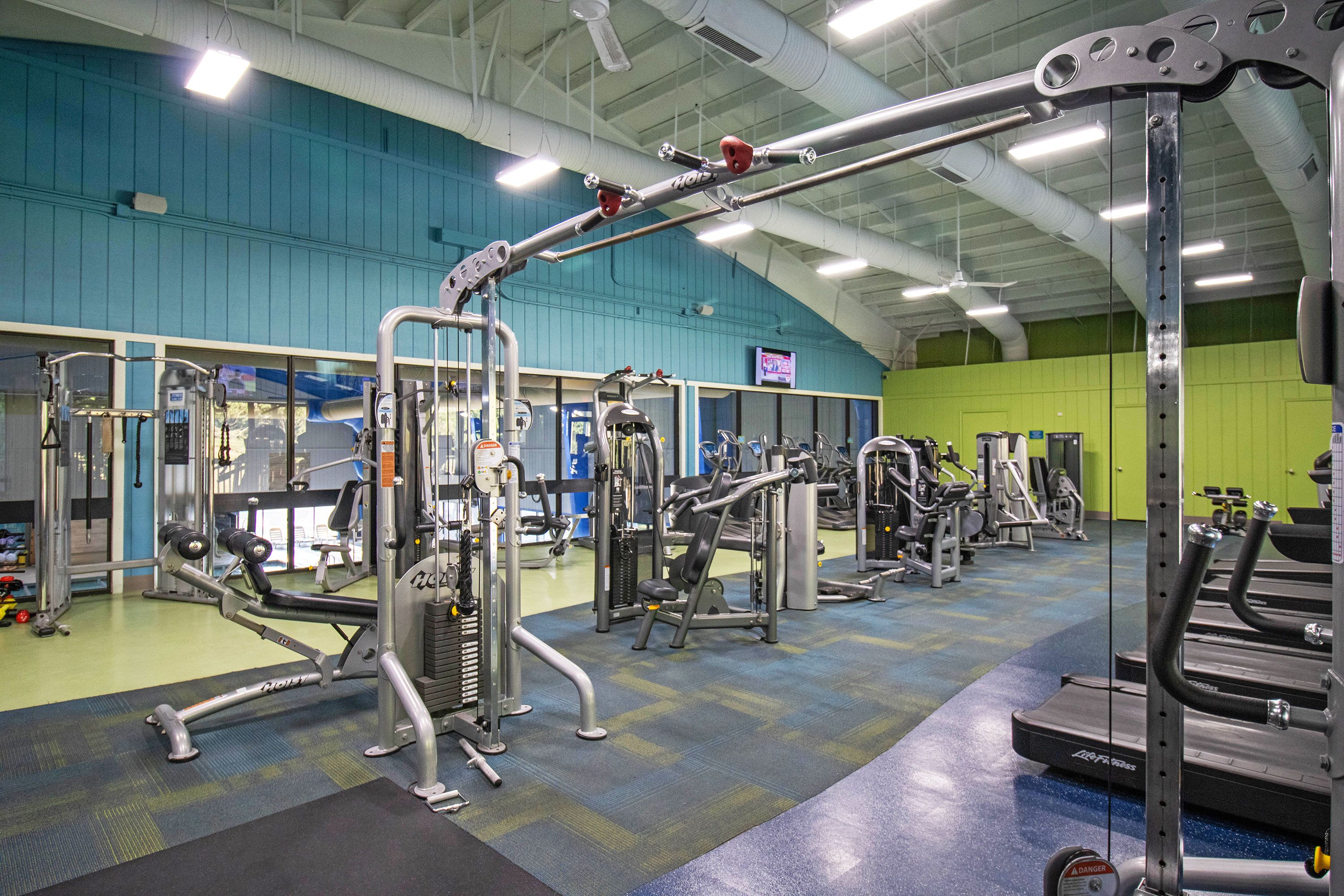 A gym with various exercise equipment, including weight machines and treadmills.
