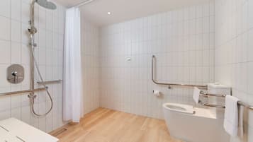 A modern bathroom with a shower, toilet, and sink.