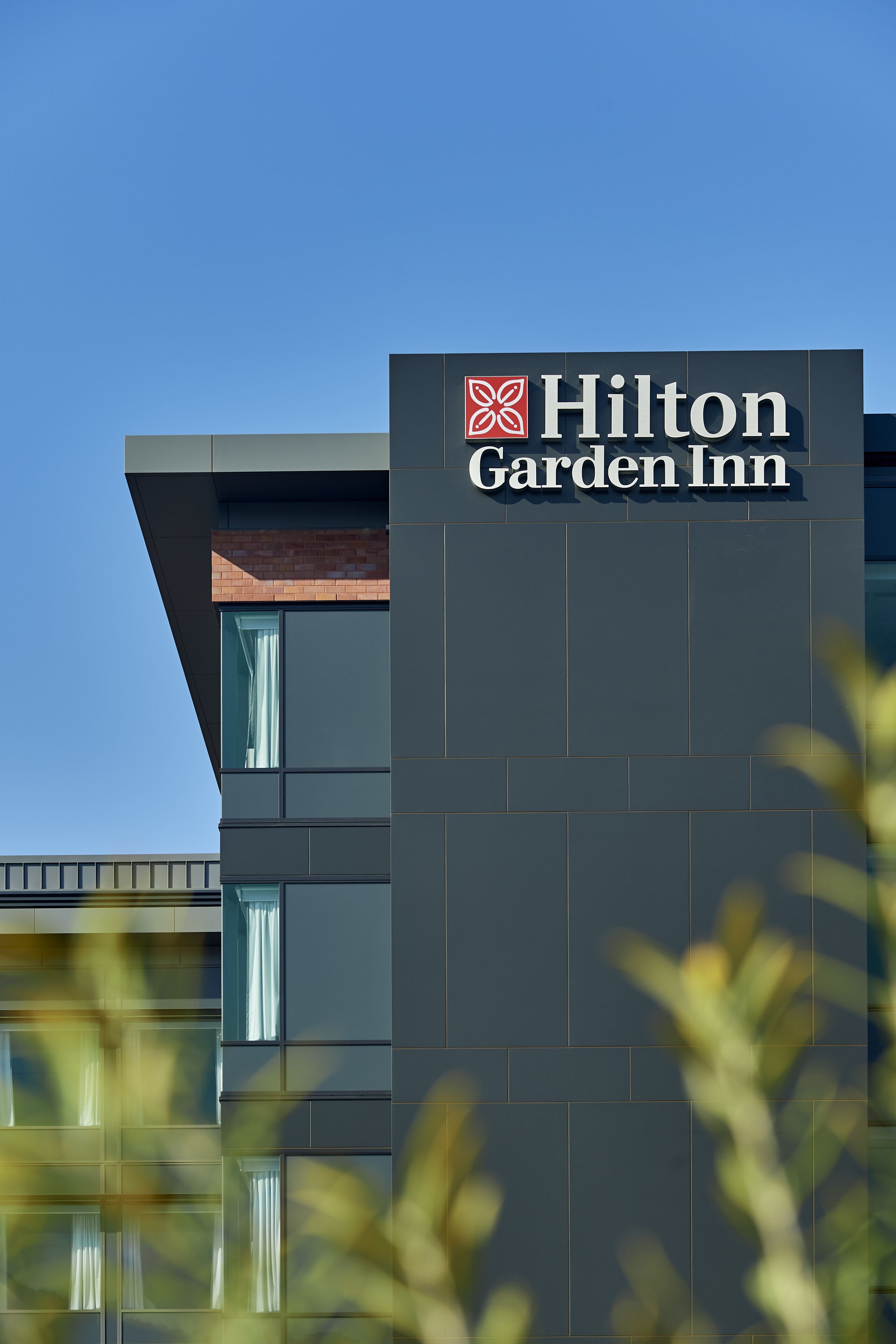 A Hilton Garden Inn sign on a modern building facade.