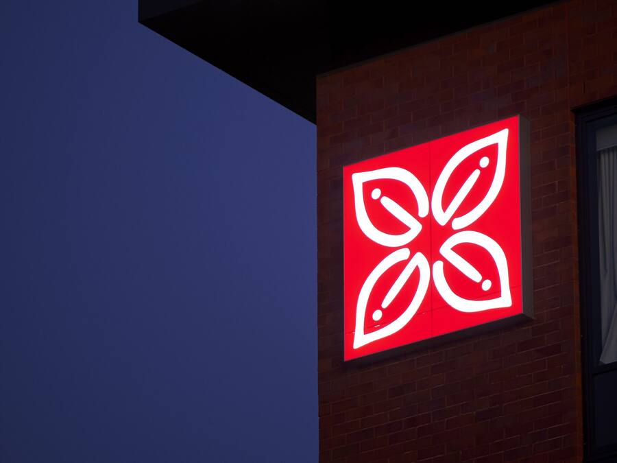 Un bâtiment avec un logo rouge sur le côté.