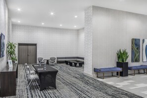 A modern conference room with a long table, chairs, a sofa, and a bench. - Embassy Suites by Hilton Atlanta Midtown (Atlanta)