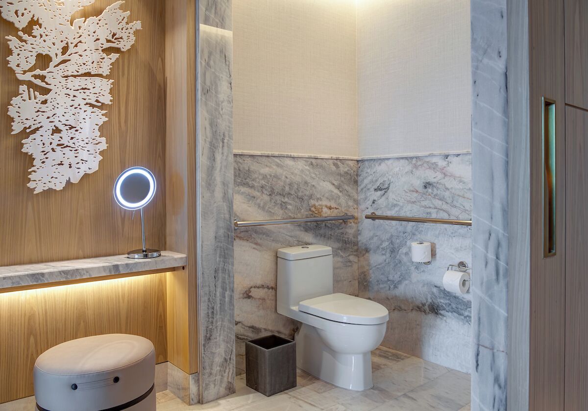 A modern bathroom with a toilet, bidet, and a vanity with a mirror.