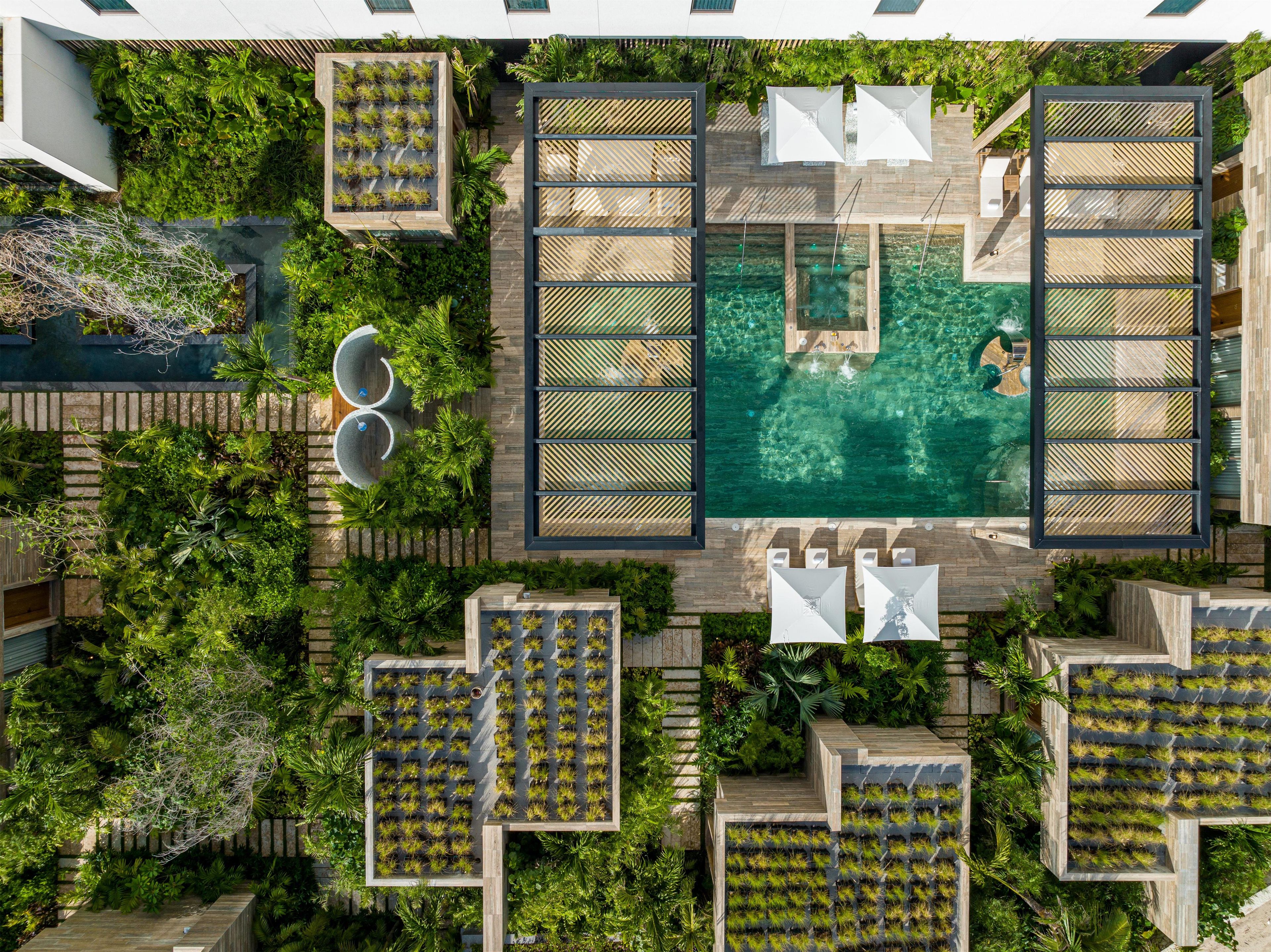 A rooftop pool area with multiple seating areas and a central water feature.