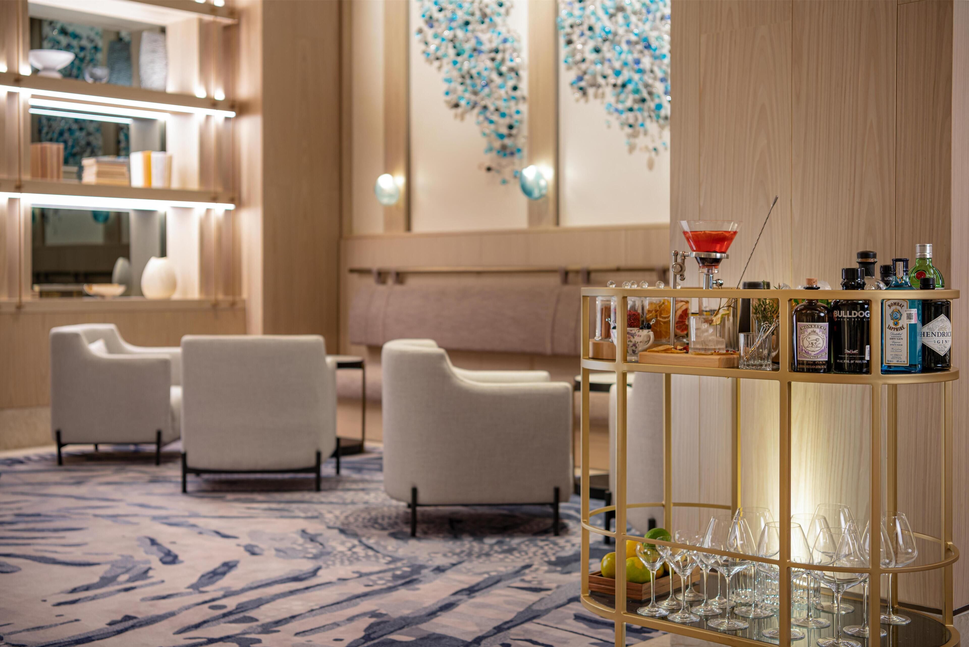 A modern hotel lobby with a bar area, seating, and decorative elements.