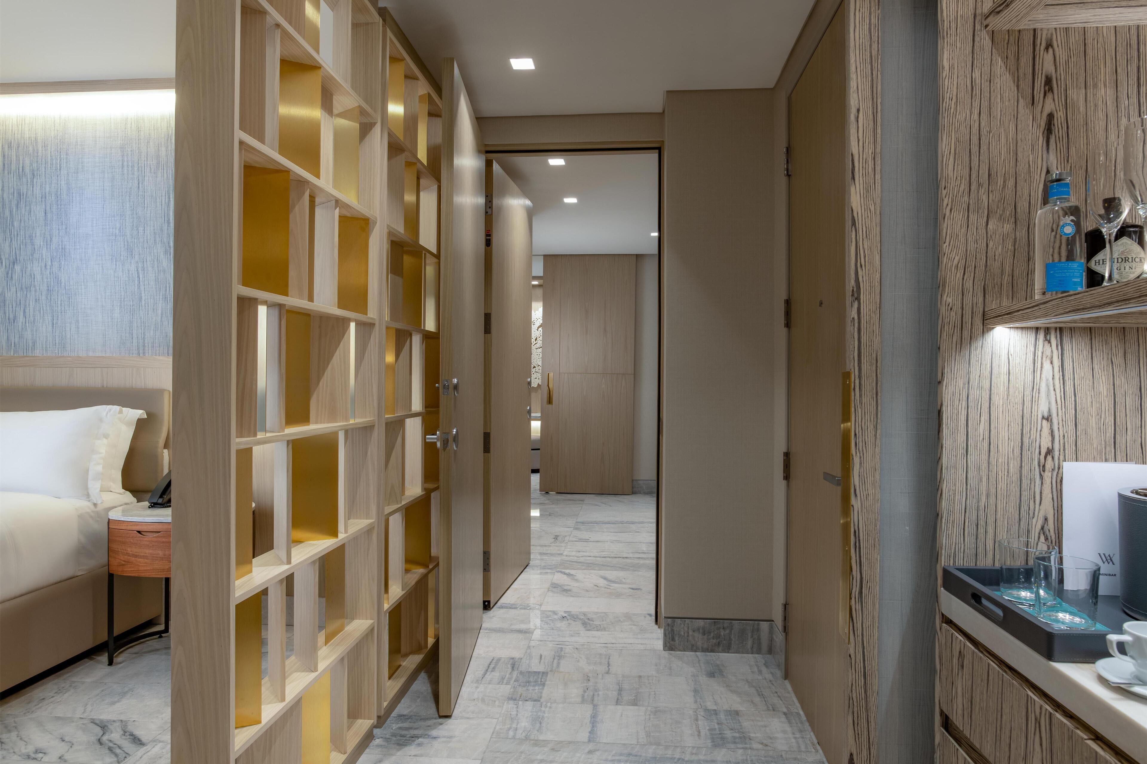 Une chambre d’hôtel comprenant un lit, une table de chevet, une armoire en bois et une salle de bain.