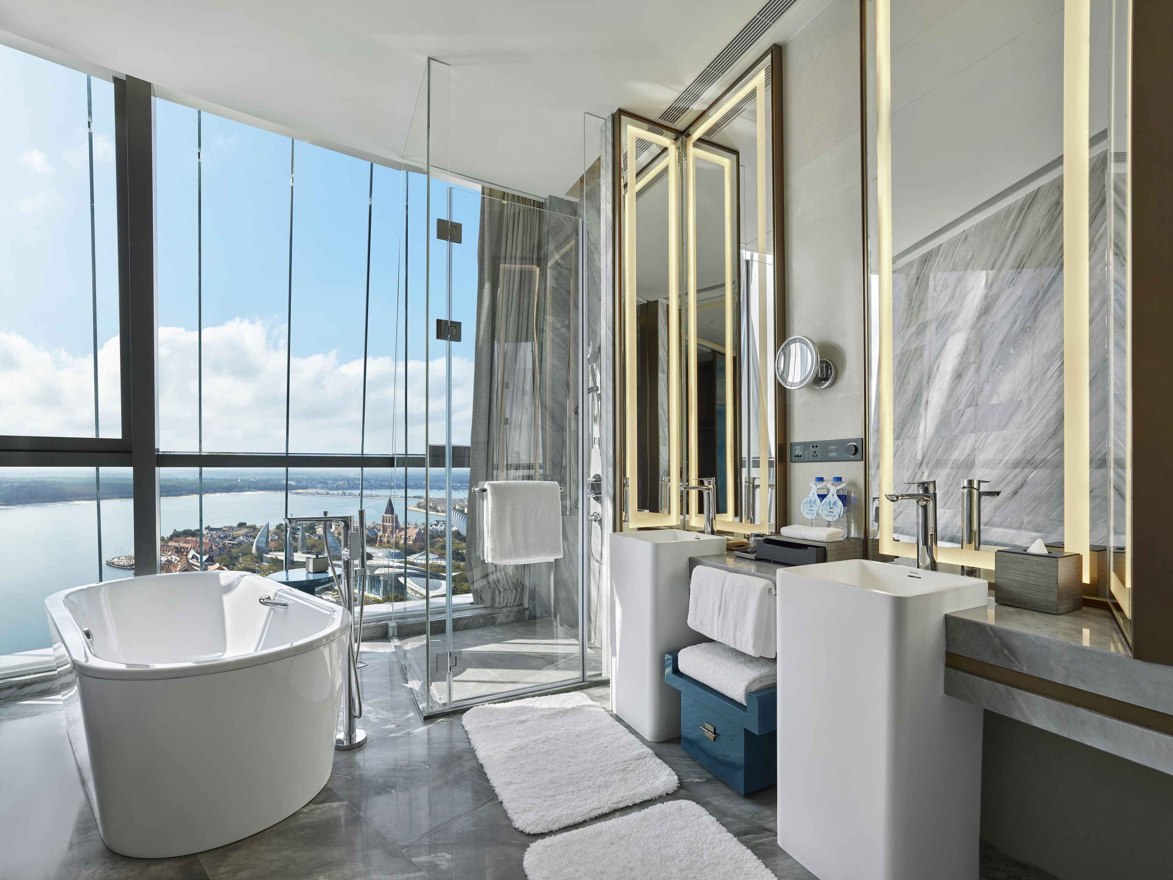 Un baño moderno con una bañera grande, dos lavamanos y un espejo amplio.