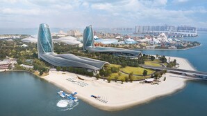 A waterfront hotel with two prominent curved towers, a beach, and a marina. - Hilton Hainan Ocean Flower Island (Danzhou)