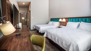 A hotel room with two single beds, a desk with a lamp, a chair, and a wooden headboard. - Hampton Inn Riverside March Air Force Base (March Air Reserve Base)