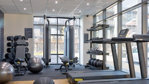 Een sportschool met loopbanden, fitnessballen en krachttrainingsapparaten.