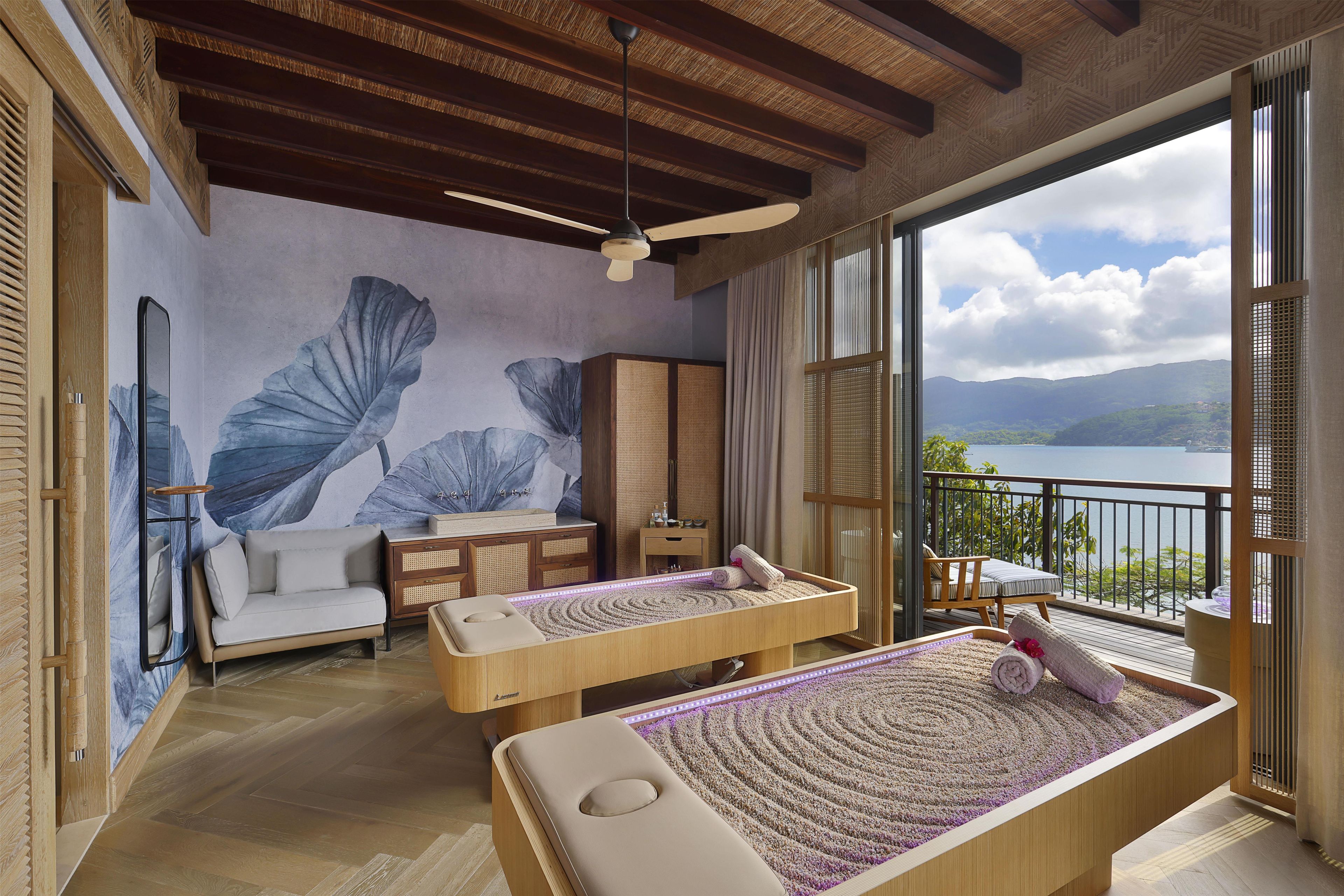 Una habitación con una camilla de masaje, un sofá y vistas a un lago.