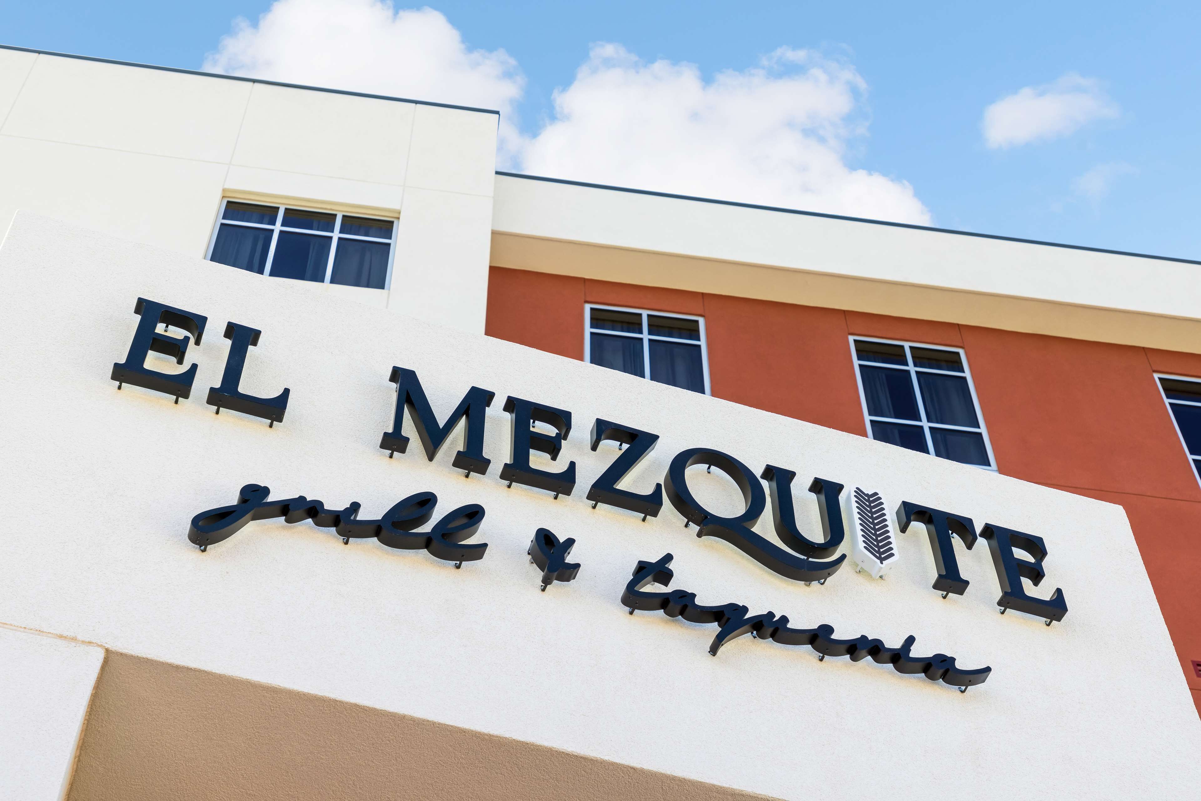 A building with a sign reading "EL MEZQUITE" and "jewel & tangle".