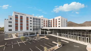 A modern hotel with a large parking lot and a glass entrance.
