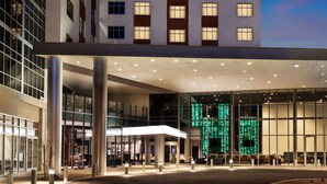 A modern building with large windows and a green-lit interior. - DoubleTree by Hilton Tucson Downtown Convention Center (Tucson)