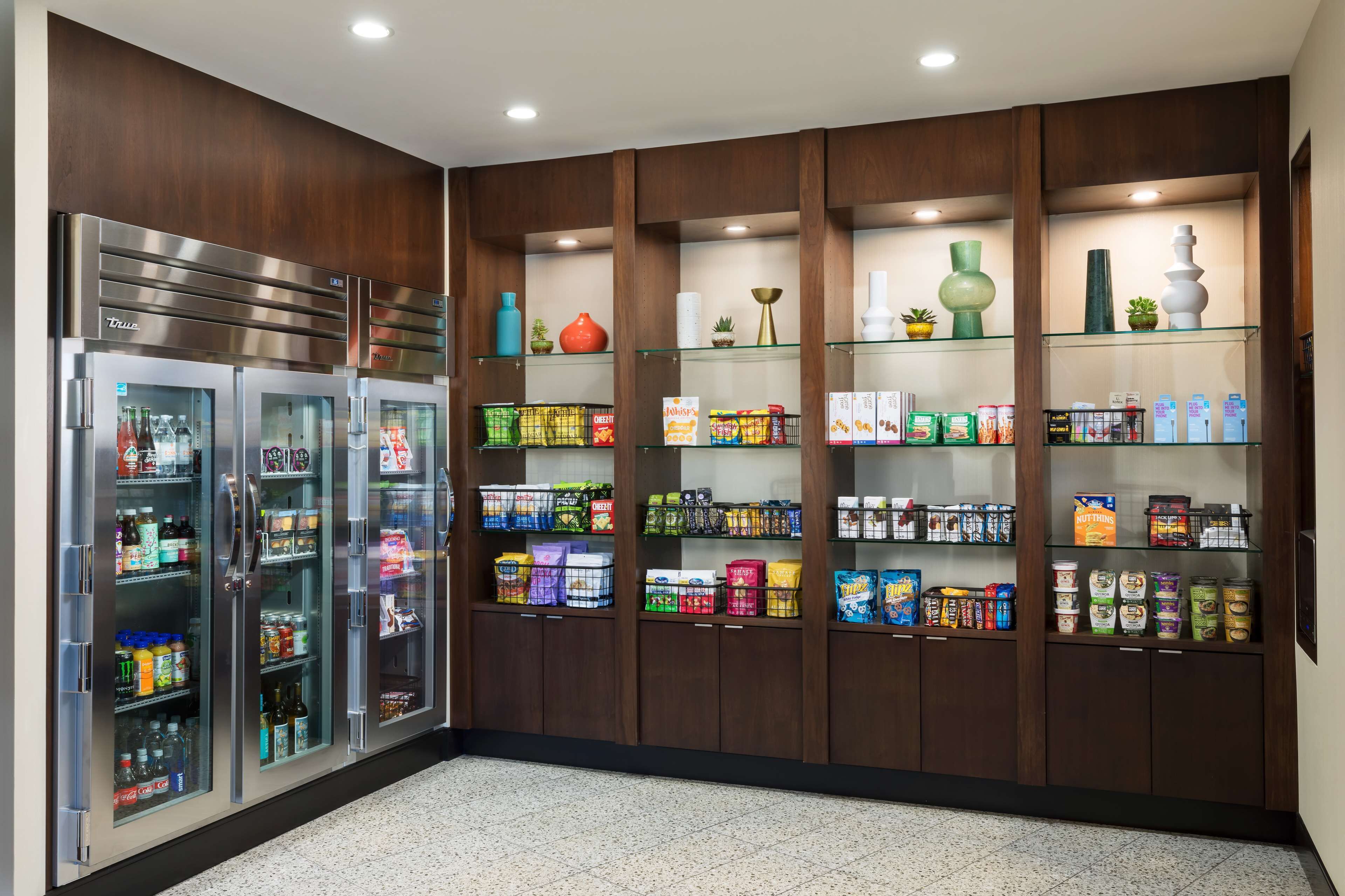 A well-lit retail area with refrigerated display cases and shelves stocked with snacks and beverages.