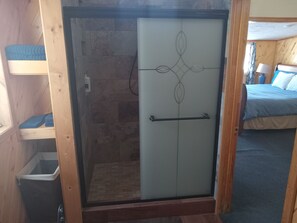 A room with a glass door, a bed with a blue bedspread, and a wooden bench. - Mountain View Lodge near Mesa Verde National Park (Dolores)