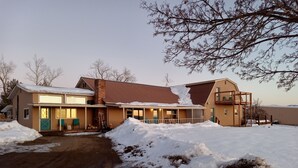 Ein zweistöckiges Haus mit einer großen Veranda und einem überdachten Außenbereich.