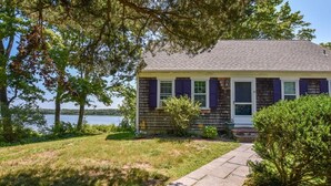 A single-story house with a gabled roof, a front porch, and a small front yard. - Waterfront on the Cove, NEW Kitchen and Central AC (Orleans)